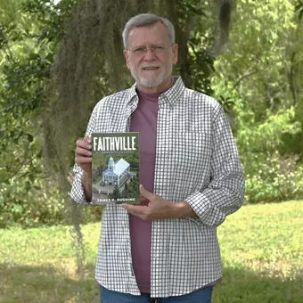 Person holding 'Faithville' book.